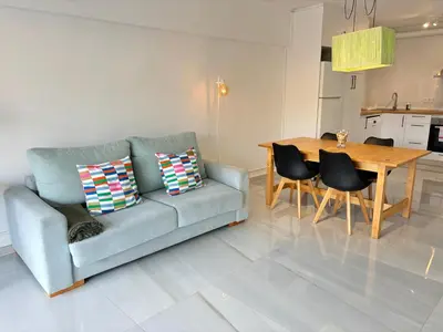 a living room with a couch and a table at Apt. En la Playa, Wifi rápido y piscina. in Puebla de Farnals