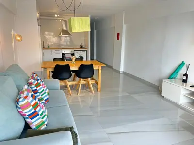 a living room with a blue couch and a table at Apt. En la Playa, Wifi rápido y piscina. in Puebla de Farnals