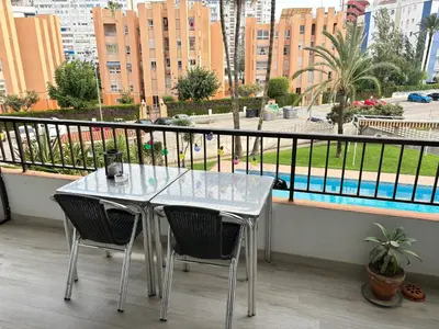 a table and chairs on a balcony with a view of a city at Apt. En la Playa, Wifi rápido y piscina. in Puebla de Farnals
