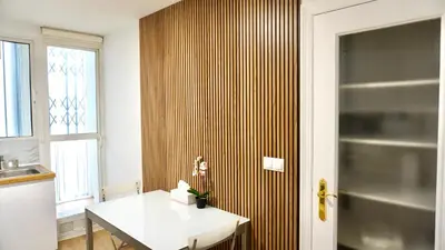 a kitchen with a table and a wooden wall at Cervantes Prime in Valencia