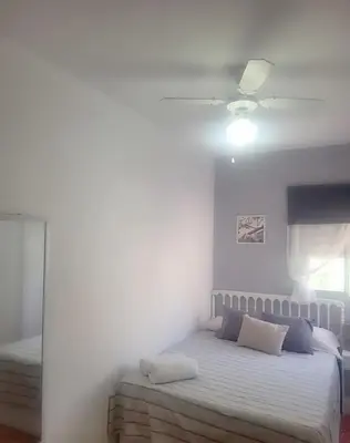 a bedroom with a bed and a ceiling fan at Amplio apartamento in Puebla de Farnals