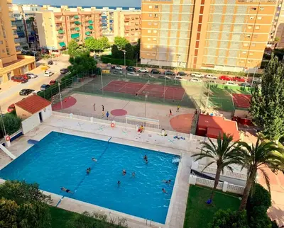an overhead view of a pool with people playing tennis at Amplio apartamento in Puebla de Farnals