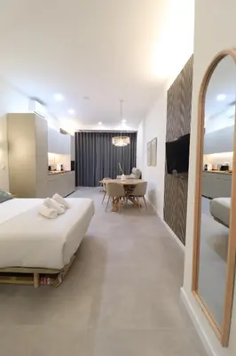 a bedroom with a large bed and a dining room at Favara Flats by Concept in Valencia