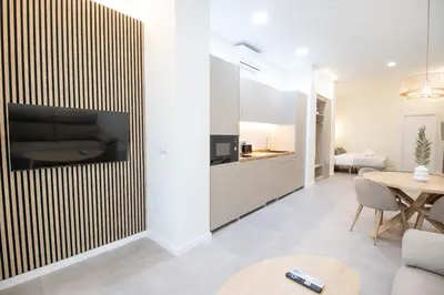 a kitchen and living room with a large tv on a wall at Favara Flats by Concept in Valencia
