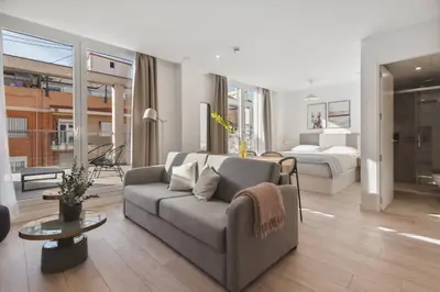 a living room with a couch and a bed at Limehome Valencia Carrer del Pare Palau i Quer in Valencia