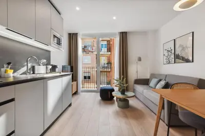 a kitchen and living room with a couch and a table at Limehome Valencia Carrer del Pare Palau i Quer in Valencia