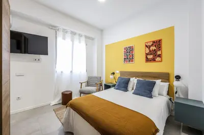 a bedroom with a large bed and a tv at Amazinn Valencia Cabanyal 2C in Valencia