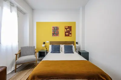 a bedroom with a bed and a chair at Amazinn Valencia Cabanyal 2C in Valencia