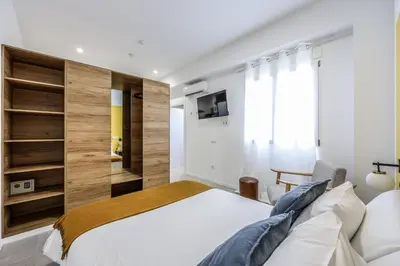a bedroom with a large white bed and a tv at Amazinn Valencia Cabanyal 2C in Valencia