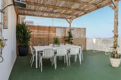 a white table and chairs under a wooden roof at Amazinn Valencia Cabanyal 2C in Valencia