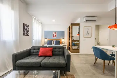 a living room with a couch and a bed at AmazINN Valencia Cabanyal 3B in Valencia