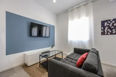 a living room with a couch and a tv at AmazINN Valencia Cabanyal 3B in Valencia