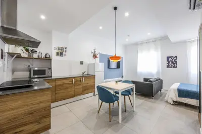 a kitchen and living room with a table and a couch at AmazINN Valencia Cabanyal 3B in Valencia