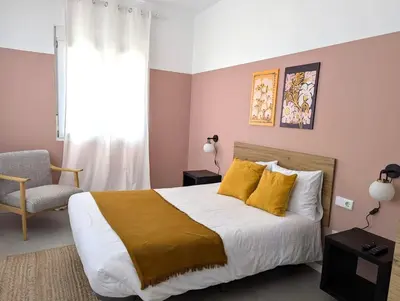 a bedroom with a bed with yellow pillows and a window at Amazinn Valencia Cabañal 3A in Valencia