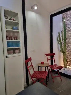 two red chairs and a table in a room with a cactus at cactus loft Ruzafa in Valencia
