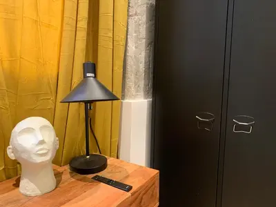 a table with a lamp and a white head bust on a table at La Reina Beach rooms in Valencia