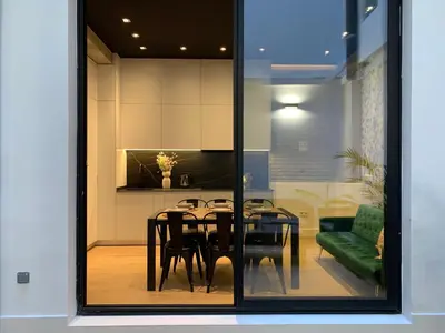 a dining room with a table and a green couch at La Reina Beach rooms in Valencia
