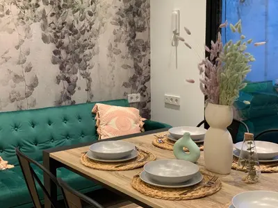 a dining room table with plates and a vase on it at La Reina Beach rooms in Valencia