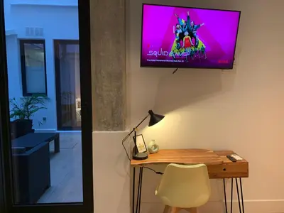 a room with a table and a tv on a wall at La Reina Beach rooms in Valencia