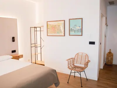 a bedroom with a bed and a chair at Demetrio By Alma Suites in Valencia