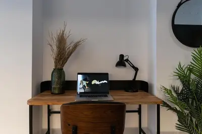a laptop computer sitting on top of a wooden table at Demetrio By Alma Suites in Valencia