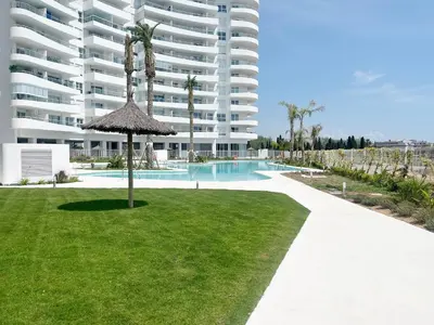 a large apartment building with a swimming pool and a lawn at Moderno apartamento con 2 terrazas en Gran Canet by Global Vacacional in Canet de Berenguer