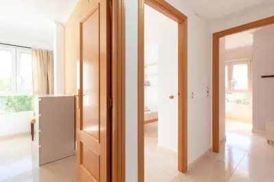 a kitchen with a door and a refrigerator in a room at Global Vacacional, Apartamento de 3 dormitorios y terraza en la playa de Canet in Canet de Berenguer