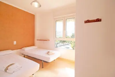 a room with two beds and a window at Global Vacacional, Apartamento de 3 dormitorios y terraza en la playa de Canet in Canet de Berenguer