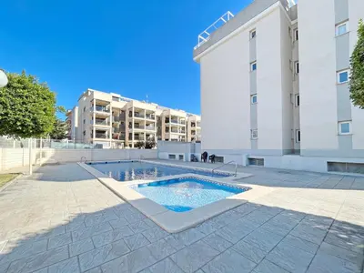 a swimming pool in front of a building at Global Vacacional, Apartamento de 3 dormitorios y terraza en la playa de Canet in Canet de Berenguer