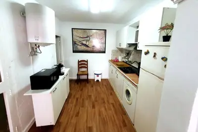 a kitchen with white cabinets and a wooden floor at Casa rural para 8 huéspedes en plena naturaleza in Gestalgar