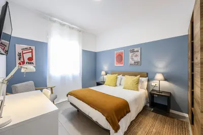 a hotel room with a bed and a desk at AmazINN Valencia Cabanyal 3D in Valencia
