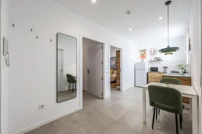 a kitchen with a table and chairs and a mirror at AmazINN Valencia Cabanyal 3D in Valencia