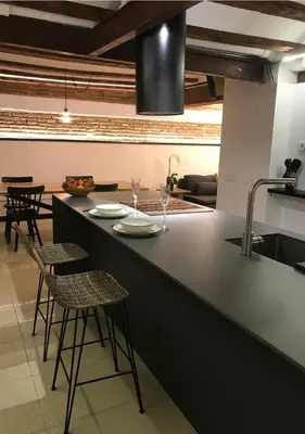 a kitchen with a counter with chairs and a sink at Estudio Pau @VALENCIAYOLE in Valencia
