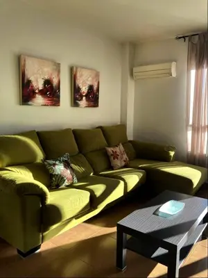 a living room with a green couch and a table at Chulillagreenhouse in Chulilla
