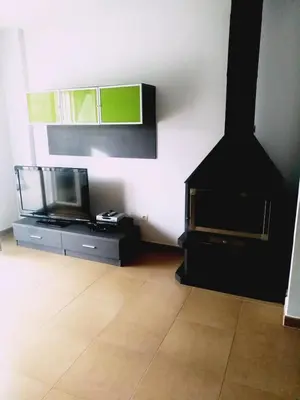 a living room with a flat screen tv and a tv stand at Chulillagreenhouse in Chulilla