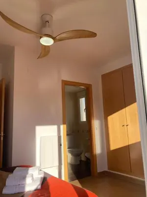 a bedroom with a ceiling fan and a bathroom at Chulillagreenhouse in Chulilla