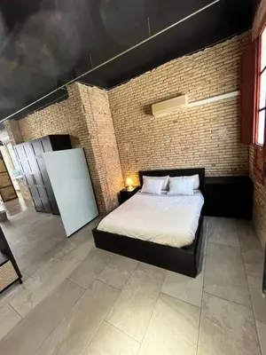 a bedroom with a bed and a brick wall at IY Loft 4 - Open Plan Garage Style - Up to 4 people in Valencia