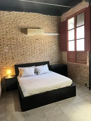 a bed in a room with a brick wall at IY Loft 4 - Open Plan Garage Style - Up to 4 people in Valencia