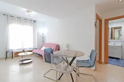 a living room with a table and chairs at Global Vacacional, Práctico apartamento muy cerca del mar en Puerto Sagunto in Puerto de Sagunto