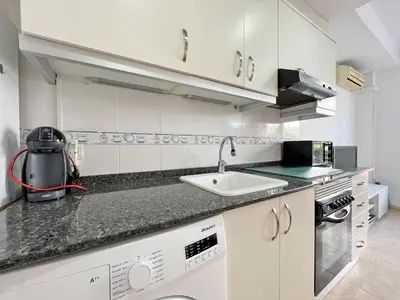 a kitchen with a sink and a counter top at Global Vacacional, Práctico apartamento muy cerca del mar en Puerto Sagunto in Puerto de Sagunto