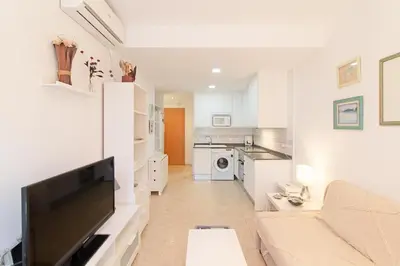 a living room with a couch and a flat screen tv at Global Vacacional, Práctico apartamento en Puerto de Sagunto cerca de la playa in Puerto de Sagunto