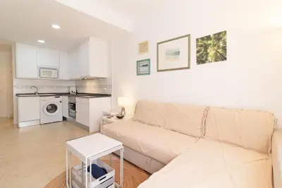 a living room with a couch and a table at Global Vacacional, Práctico apartamento en Puerto de Sagunto cerca de la playa in Puerto de Sagunto