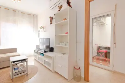a white room with a tv and a mirror at Global Vacacional, Práctico apartamento en Puerto de Sagunto cerca de la playa in Puerto de Sagunto