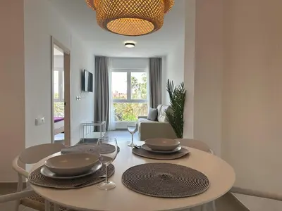 a dining room with a table and chairs and a room with a couch at Almar 52 Suites in Valencia