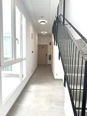 a hallway with a staircase in a building with windows at Almar 52 Suites in Valencia