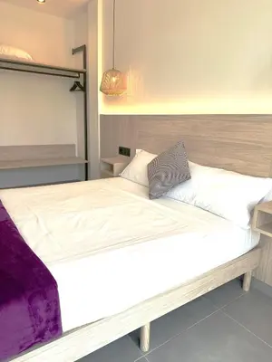 a large bed with white sheets and a purple blanket at Almar 52 Suites in Valencia