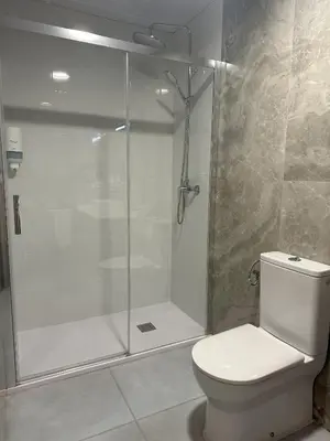 a bathroom with a shower and a white toilet at Almar 52 Suites in Valencia