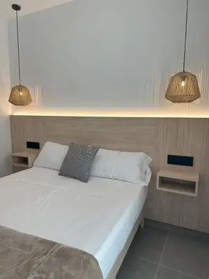 a bedroom with a white bed with two lamps at Almar 52 Suites in Valencia
