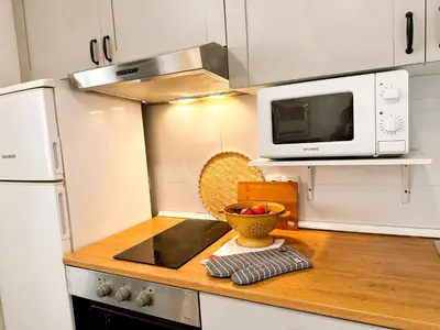 a kitchen with a microwave and a bowl of fruit on a counter at apartamento muy próximo a Valencia in Burjasot