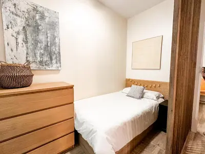 a bedroom with a bed and a wooden dresser at apartamento muy próximo a Valencia in Burjasot